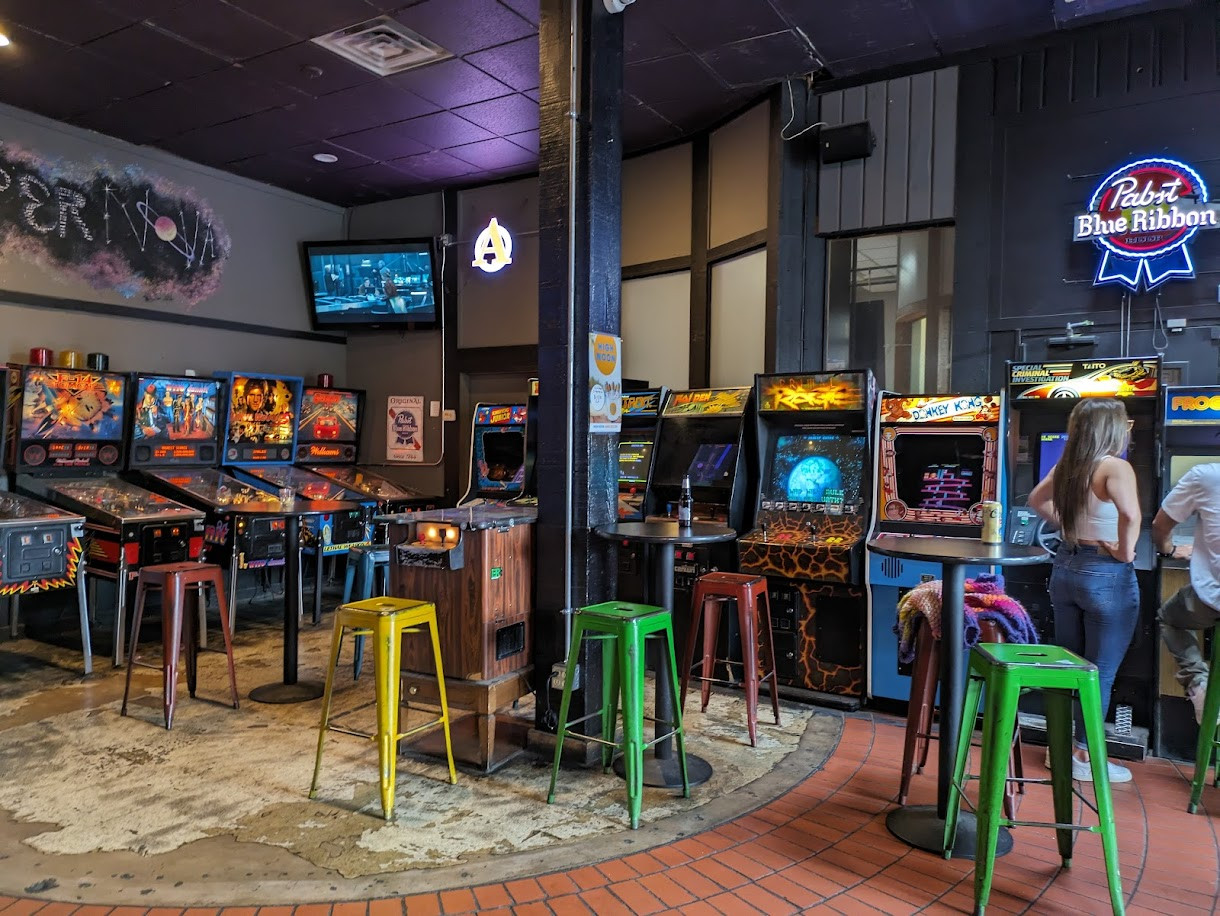 Một góc trò chơi tại Soft Landing Arcade với ánh đèn neon và không khí vui nhộn