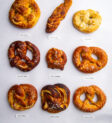 Chín chiếc bánh pretzel với nhãn trên nền xám.