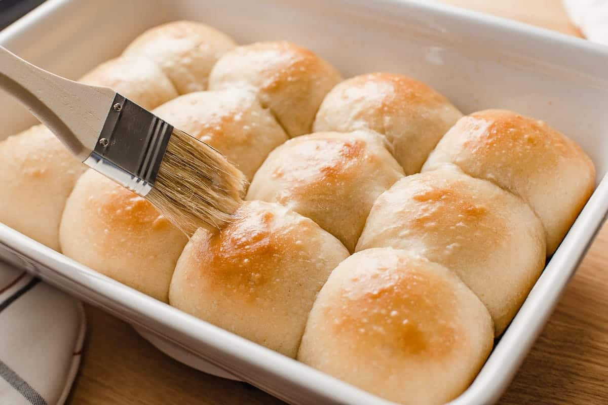 Người phụ nữ đang phết bơ lên bánh mì sourdough mới nướng.