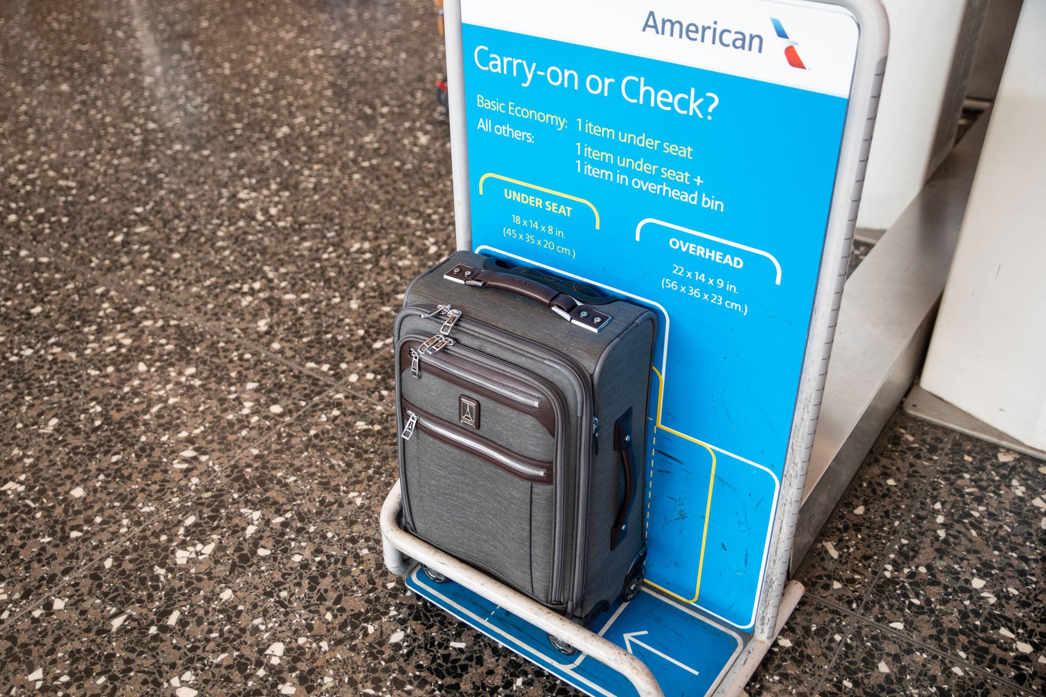 Túi xách Travelpro Platinum Elite 21 inch màu đen, đặt trước sơ đồ kích thước hành lý xách tay của American Airlines để chứng minh rằng nó sẽ vừa với ngăn chứa đồ trên máy bay.