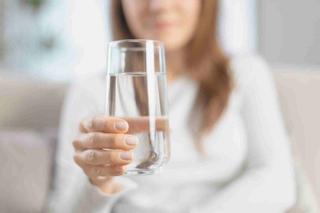 Một người phụ nữ đang cầm một ly nước.