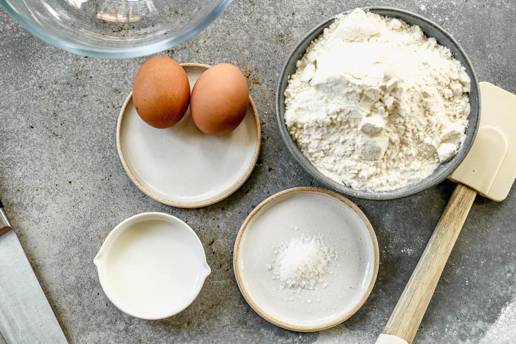 Trứng, bột mì, muối, sữa - những nguyên liệu đơn giản để làm mì trứng tươi tại nhà.