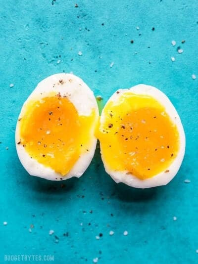 Trứng lòng đào cắt đôi trên nền xanh, lòng đỏ tan chảy, hấp dẫn