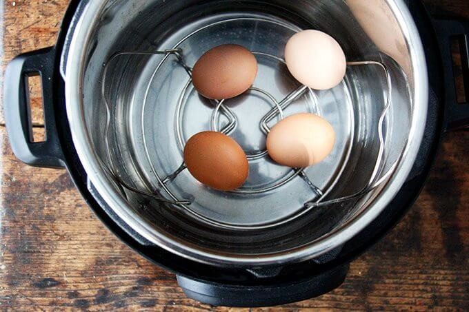 Chuẩn bị nồi Instant Pot với vỉ hấp và nước sẵn sàng cho việc luộc trứng.