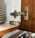 Soft close adapter installed on a cabinet door, showing the damper mechanism aligned for smooth closing