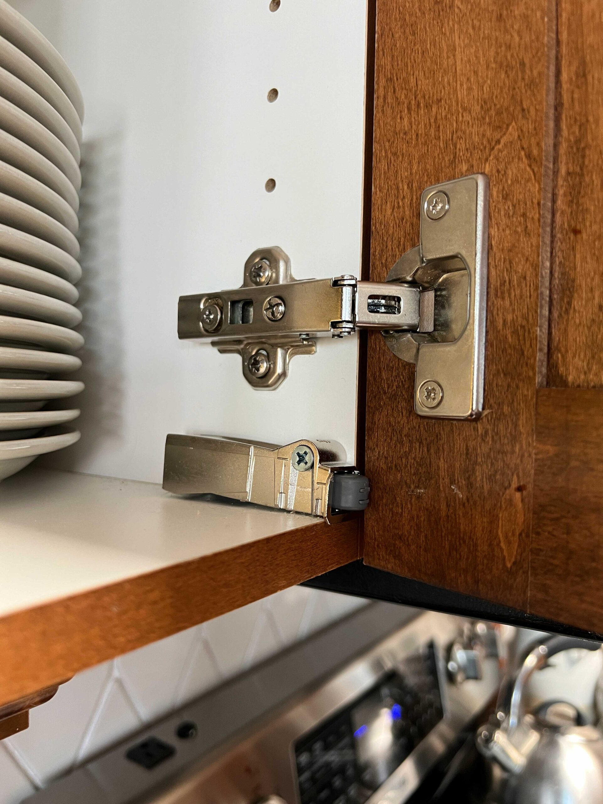 Soft close adapter installed on a cabinet door, showing the damper mechanism aligned for smooth closing