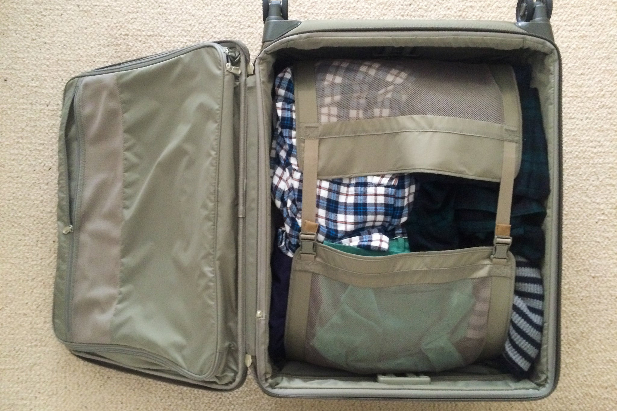 Top view of folded clothes buckled in the main compartment of a Briggs &amp; Riley Baseline Medium Expandable 25-inch Spinner.